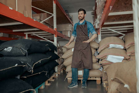 Business owner standing near bags with coffee beans in the coffee small factoryの写真素材