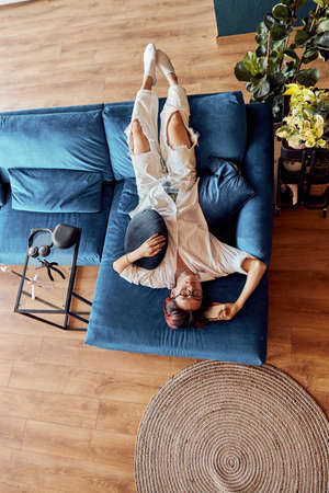 Young Asian guy in glasses sleeping on sofa at homeの写真素材