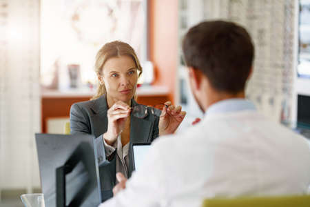 The ophthalmologist helps the client to choose a more suitable spectacle frame