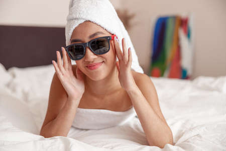 Asian young woman in sunglasses relaxing at homeの写真素材