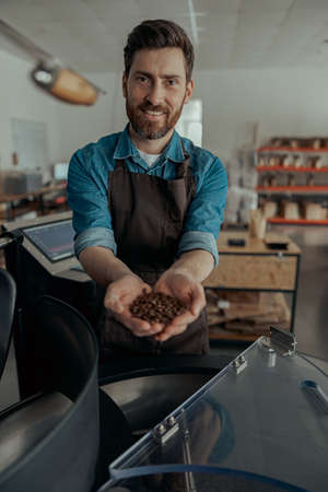 Male business owner demonstrate freshly roasted coffee beans