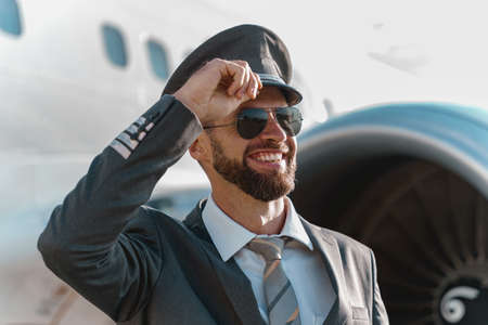 Close up of Joyful aircraft pilot standing outdoors at airfieldの写真素材