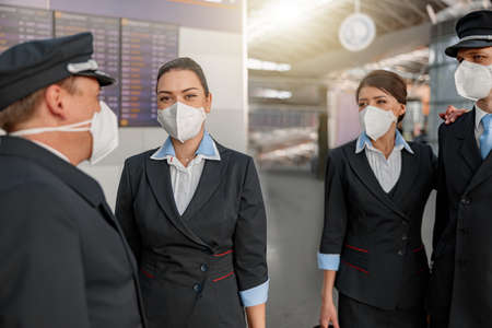 Flight team standing together in airport terminalの写真素材