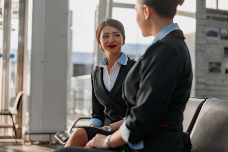 Beautiful stewardess looking at her colleague in the terminalの写真素材