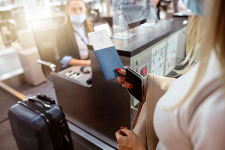 Woman holding passport and tickets near reception deskの写真素材