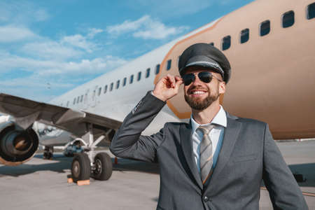 Joyful aircraft pilot standing outdoors at airfield