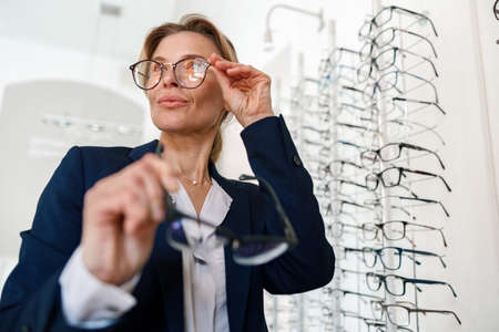 Businesswoman buys glasses in an optical storeの写真素材