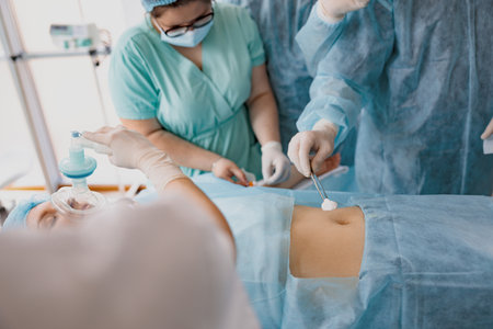 Nurse and doctor prepare patient skin for surgery using antiseptic solutionの写真素材