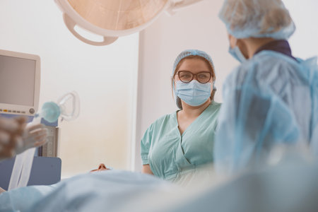 Nurse assisting doctors during surgery in operation room of modern clinic. Blurred backgroundの写真素材