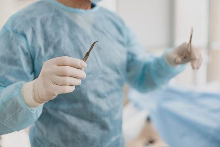 Close up of doctors hand holding scalpel and forceps in operation room at the hospitalの写真素材