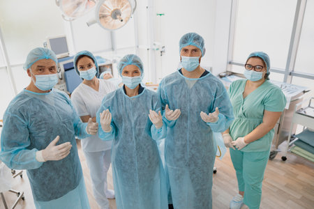 Team of surgeons in the operating room ready for surgery in clinic looking at cameraの写真素材