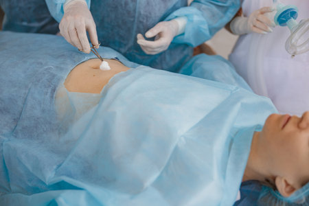 Nurse and doctor prepare patient skin for surgery using antiseptic solutionの写真素材