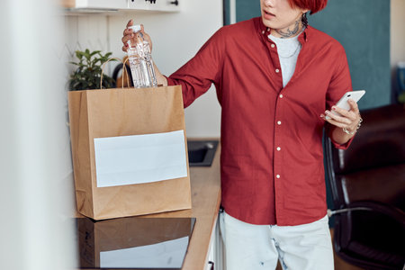 Asian guy checking online home delivery of groceriesの写真素材