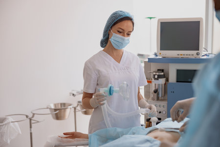 Nurse holding breathing mask during operation in medical clinicの写真素材