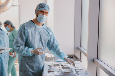 Professional doctor surgeon takes scalpel before surgery in operation room at the hospitalの写真素材