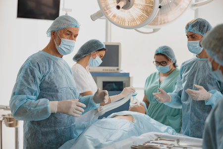Concentrated surgical team working with a patient in an operation room of modern clinicの写真素材