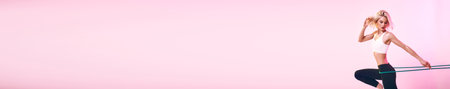 Young woman exercising with resistance band on pink background, panoramic banner