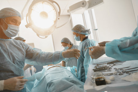 Assistant hands out instruments surgeon during surgery in the operating roomの写真素材