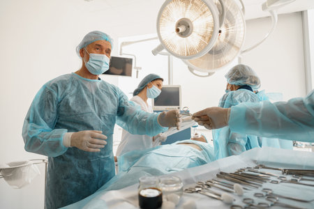 Assistant hands out instruments surgeon during surgery in the operating roomの写真素材