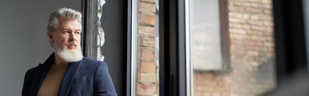 Pensive middle aged man in business casual wear looking out a laの写真素材