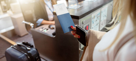 Woman holding passport and tickets near reception deskの写真素材
