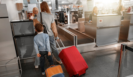 Mom and son holding suitcases and going through passport controlの写真素材