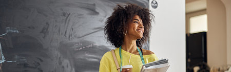 African-American fashion designer with tape measure, cup and papers at sewing classの写真素材