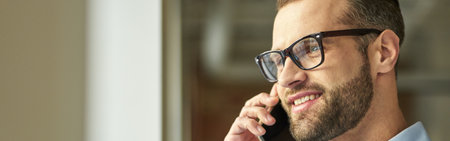 Gladsome handsome man feeling happy at the phone talkの写真素材