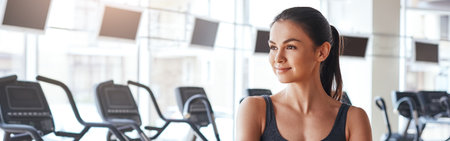 Healthy lifestyle. Young and sporty woman in sportswear with crossed arms is looking away while standing at gym.の写真素材