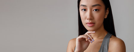 Asian woman with dark hair standing in studioの写真素材