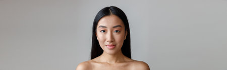 Asian young woman with dark hair standing in studioの写真素材