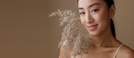 Joyful Asian woman with cereal grass standing in studioの写真素材