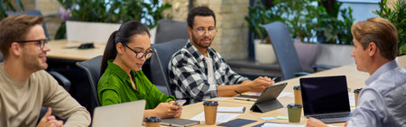 Group of young multiracial business people sitting at desk in the board room and working on project together, discussing work and sharing ideasの写真素材