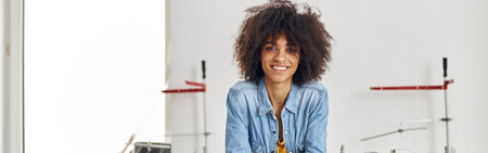 Portrait of smiling African-American woman with mobile phone leaの写真素材