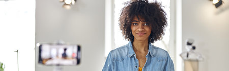 African-American woman designer shoots video for blog at cutting table with toolsの写真素材