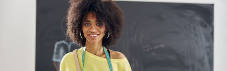 Smiling African-American student with palettes and colored paperの写真素材