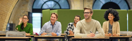 Group of multiracial business people sitting in the modern office and listening to coach or speaker during corporate seminarの写真素材
