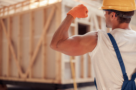 Athletic young man builder demonstrating his muscular armの写真素材