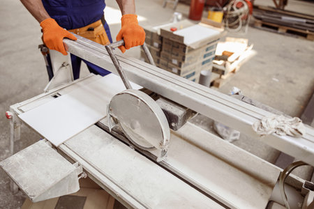 Male worker using sawing machine in workshopの写真素材