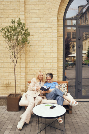 Mature business women are working together while sitting in cafe and making notesの写真素材