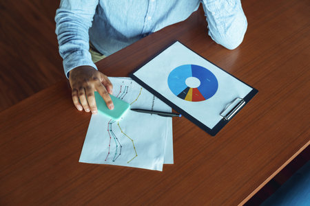 Close up of male analytic working with graphics and charts in office during working dayの写真素材