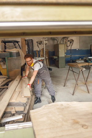 Professional male carpenter working on carpentry manufacturing with wooden boardの写真素材