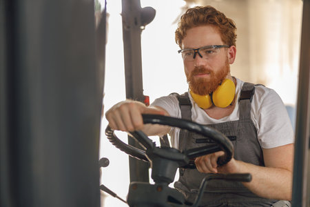 Professional forklift driver in working in wood warehouse and loading wooden board