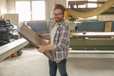 Professional male carpenter working on carpentry manufacturing with wooden boardの写真素材