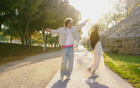 A Joyful Couple Enjoying a Blissful Sunlit Stroll Together in the Beautiful Outdoors of Natureの写真素材