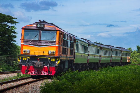Train passing through the curve in countryside on a nice summer day with blue sky.の写真素材