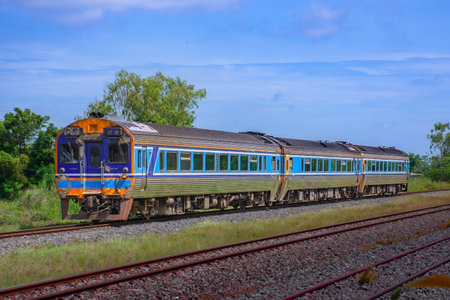 Diesel railcar on the railway in the countryside of Thailand with blue sky.の写真素材