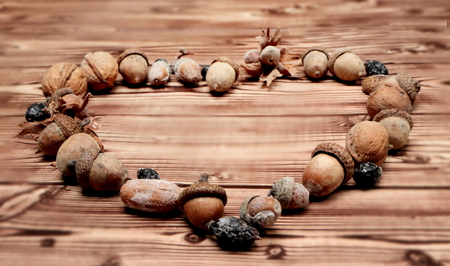 Heart of autumn harvest acord and nuts on wooden backgroundの写真素材