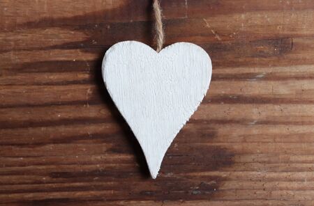White heart on brown wooden background photoの写真素材