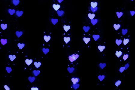 Various Christmas lights blues  illuminated heart shape blurred with cool colors and dark backgroundの写真素材